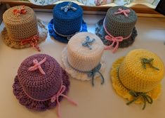 six crocheted hats with bows on them