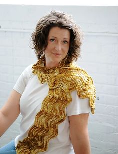 a woman sitting down wearing a yellow scarf