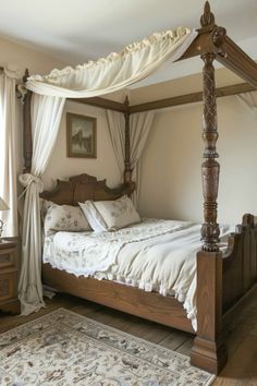 a canopy bed with white sheets and pillows