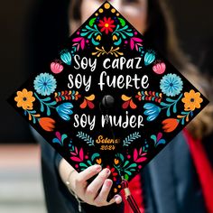 a woman wearing a graduation cap that reads soy caraz soy fuerte soy mueder