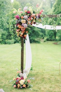 an outdoor ceremony setup with flowers and greenery