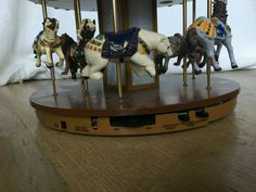 an old fashioned carousel with four horses on it