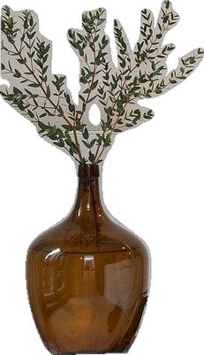 a brown glass vase with green leaves in it on a white background, for decoration