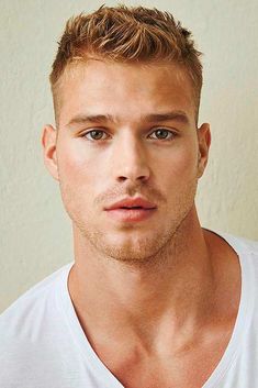 a close up of a person wearing a white t - shirt and looking at the camera