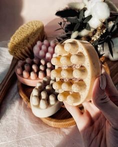 a person holding an object in front of some other items on a plate with flowers