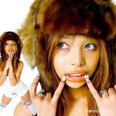 a woman wearing a fur hat and holding her hands up to her mouth