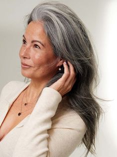 an older woman with gray hair is talking on her cell phone