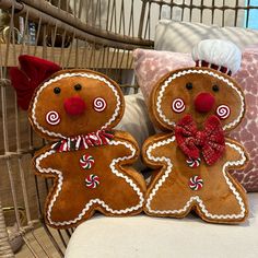 two gingerbread men sitting next to each other on a chair in front of pillows