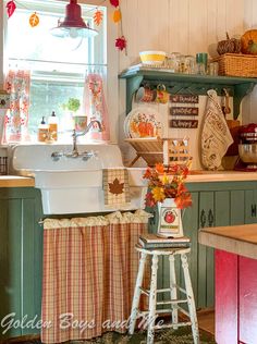 a kitchen with green cabinets and an old fashioned sink in the center is decorated with fall decorations