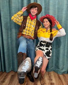 a man and woman dressed up in western clothing sitting on the floor with their legs crossed