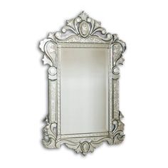 an ornate silver framed mirror on a white wall