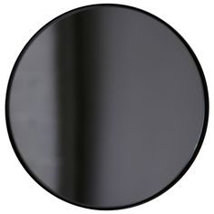 a black round mirror on a white wall