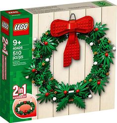 a christmas wreath made out of legos on top of a wooden wall next to a box