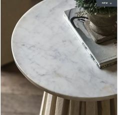 a white marble table with a book on top