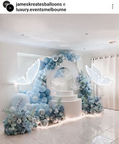 a white and blue wedding cake surrounded by balloons