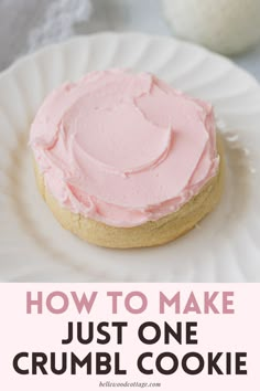 a pink frosted cookie on a white plate