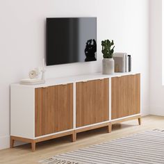 a television mounted on the side of a wooden cabinet next to a potted plant