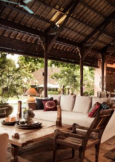 an outdoor living area with couches, tables and lamps