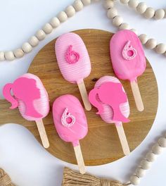 pink elephant lollipops sitting on top of a wooden board