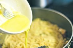 someone is pouring sauce on some pasta in a pot