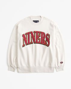 a white sweatshirt with the word niners on it in red and black letters,