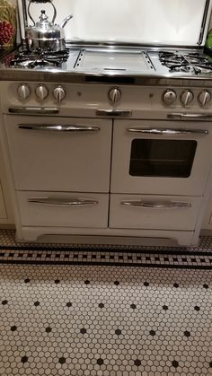 a white stove top oven sitting inside of a kitchen