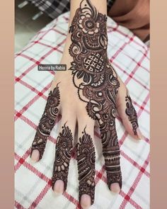 a woman's hand with henna tattoos on it