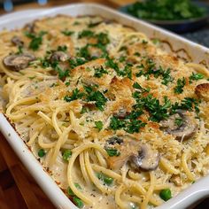 a casserole dish with pasta, mushrooms and parmesan cheese on top