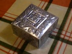 a metal box sitting on top of a checkered table cloth