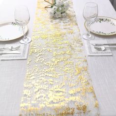 the table is set with white and gold place settings