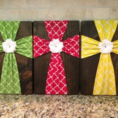 three wooden crosses decorated with bows on top of a counter