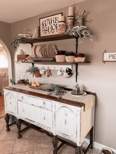 an old buffet table is decorated with dishes and other things on it's shelves