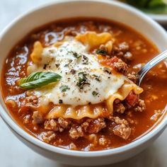 a white bowl filled with meat and cheese soup