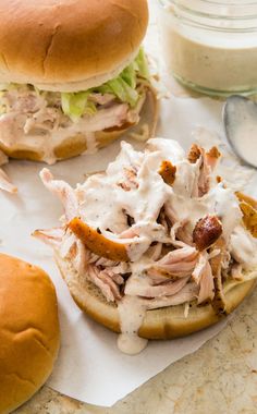 two pulled pork sandwiches on buns with ranch dressing