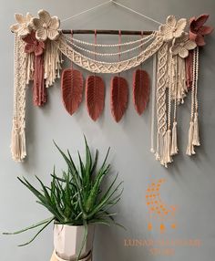 a potted plant sitting on top of a wooden table next to a wall hanging