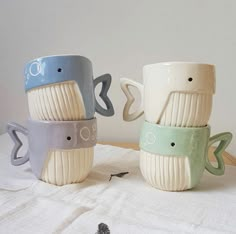 three ceramic cups sitting on top of a table