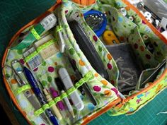 the inside of an orange and green bag with scissors, pens, pencils and other items in it