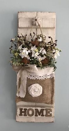 an old door is decorated with flowers and the word home hanging on it's side