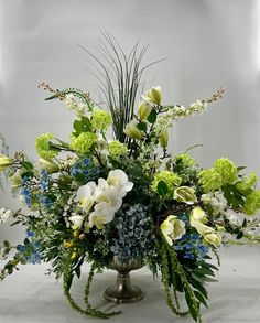 a vase filled with lots of white and blue flowers