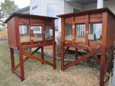 two chicken coops sitting in the middle of a yard