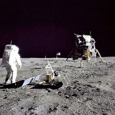 an astronaut walking on the surface of the moon next to another man in space suit