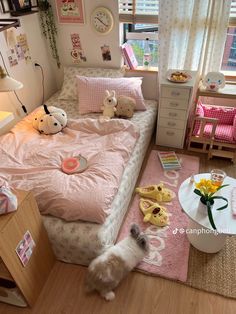 a small white dog standing in front of a bed with pink comforter and pillows