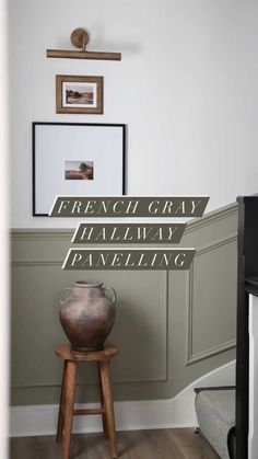 a vase sitting on top of a wooden stool in front of a wall with the words french gray halfway paneling