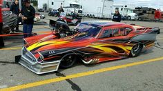 a car with flames painted on it parked in a parking lot