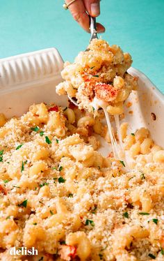 a person is scooping some food out of a casserole dish on a blue table