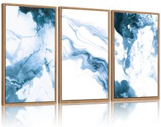 three abstract paintings in gold frames with blue and white paint on the wall behind them