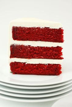 a slice of red velvet cake with white frosting