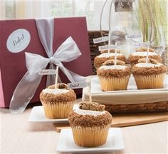 some cupcakes are sitting on plates near a box