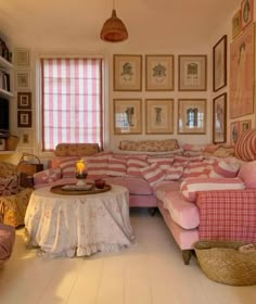 a living room filled with furniture and pictures on the wall