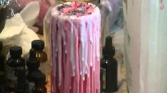 a birthday cake with pink icing and sprinkles sitting on a table